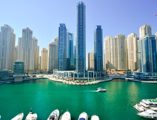 InterContinental Dubai Marina waterfront hotel with modern high-rise towers overlooking turquoise marina waters and moored boats, Dubai UAE