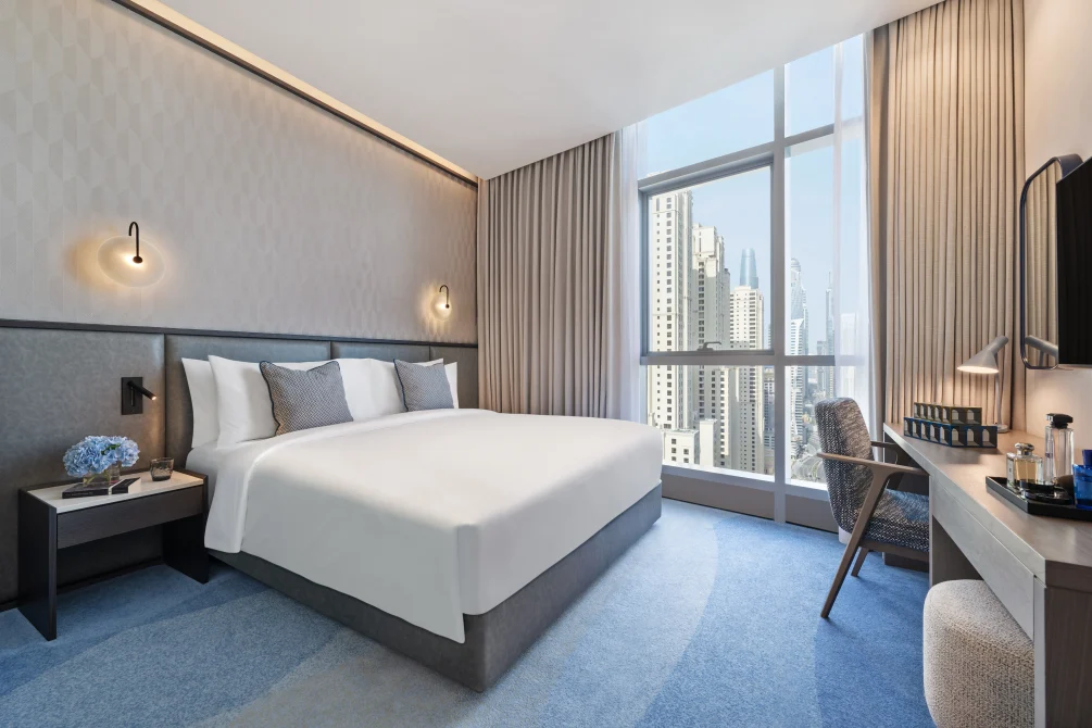 Modern guest room with king bed, desk, and Dubai Marina skyline view at InterContinental Dubai Marina