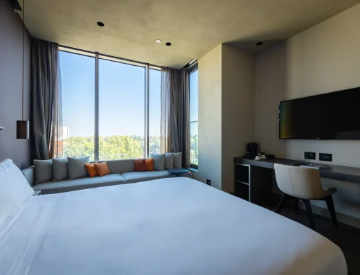 Superior Premium room at Hotel VIU Milan with large windows, daybed seating, and desk