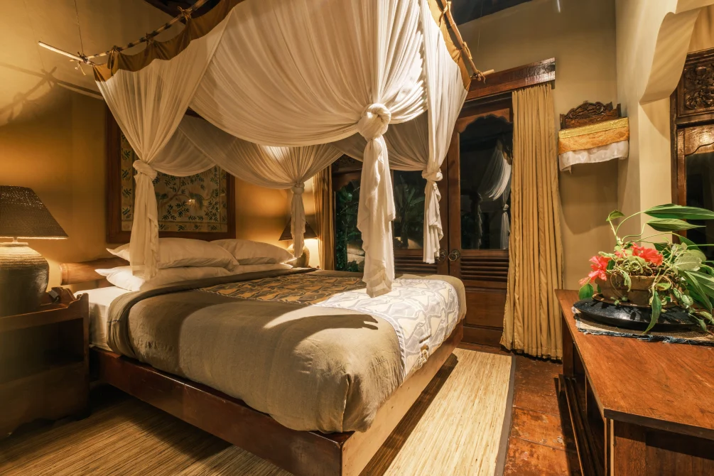 Cozy bedroom with a canopy bed and mosquito net in a bungalow at Sarinbuana Eco lodge, Bali