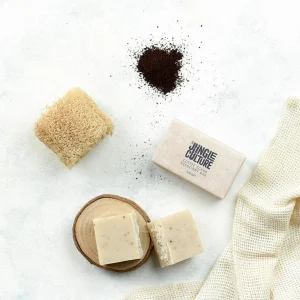 Coffee body solid soap bar by Jungle Culture with coffee grounds, natural loofah, and soap pieces on a white background.