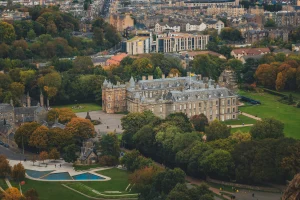 Aerial view of Holyrood Palace with Edinburgh cityscape and green parks