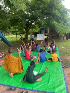 Outdoor lesson with local children and volunteers in Cambodia.