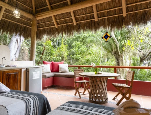 Open-air jungle suite with kitchenette and terrace seating at Tailwind Jungle Lodge